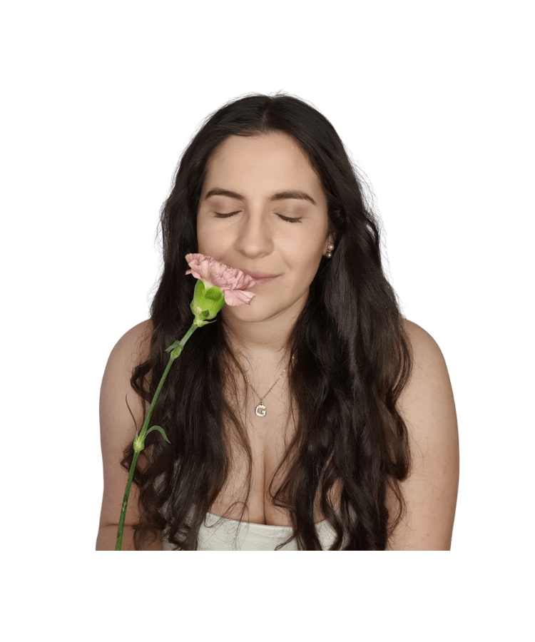 Gabriela is smelling a pink flower